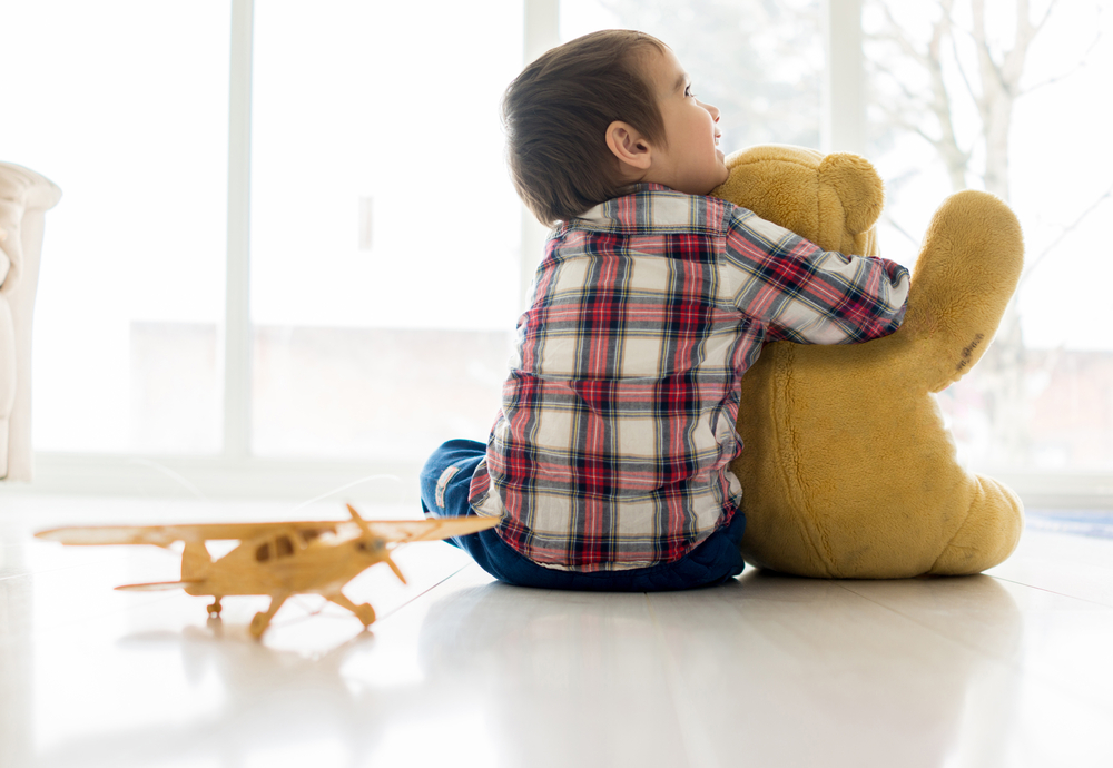 Portrait of child sitting in living room with Teddy bear Portrait of child sitting in living room with Teddy bear