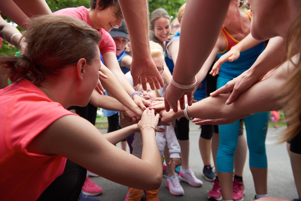 jogging people group, friends have fun, hug and stack hands together after training jogging people group, friends have fun, hug and stack hands together after training